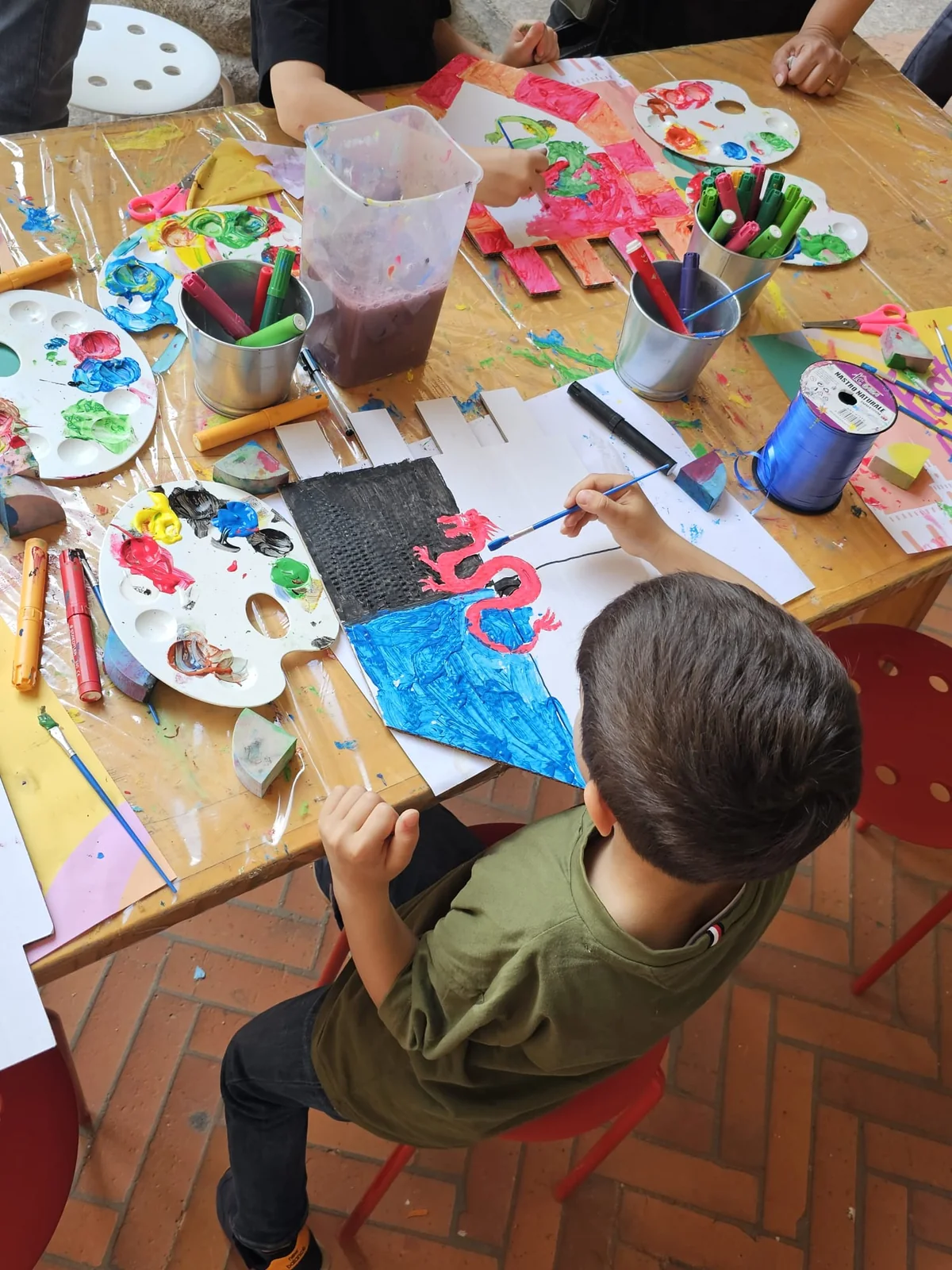 Un bambino dipinge il proprio stendardo al Festival delle Bambine e dei Bambini