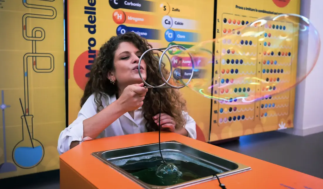 Una divulgatrice soffia una bolla di sapone gigante durante una dimostrazione